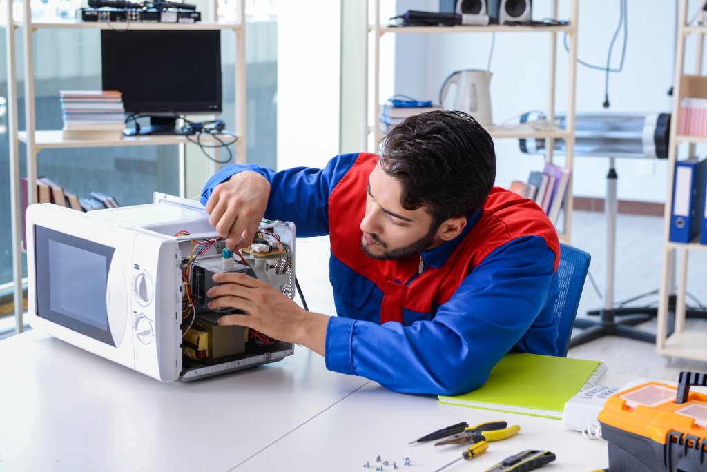 man fixing microwave