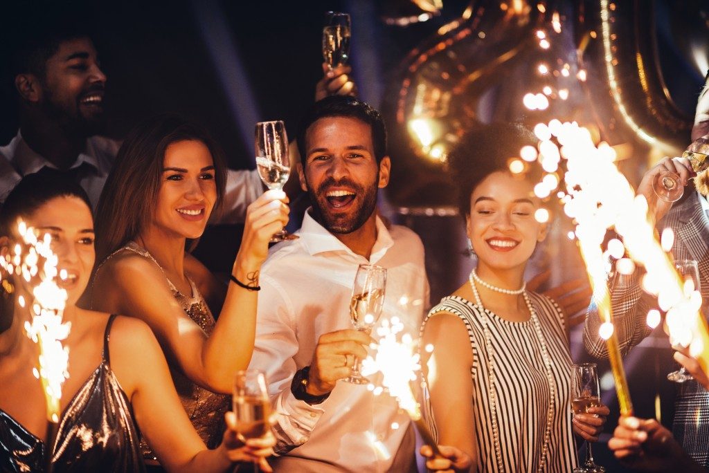 group of people drinking wine and lighting fireworks