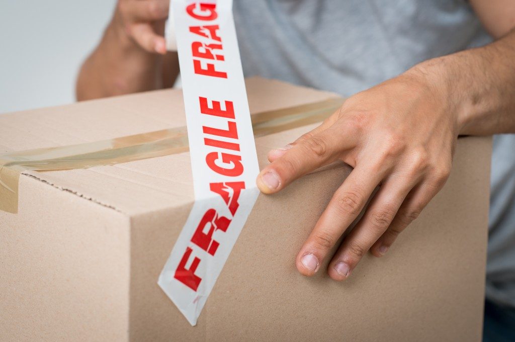 fragile tape being used over a packed box