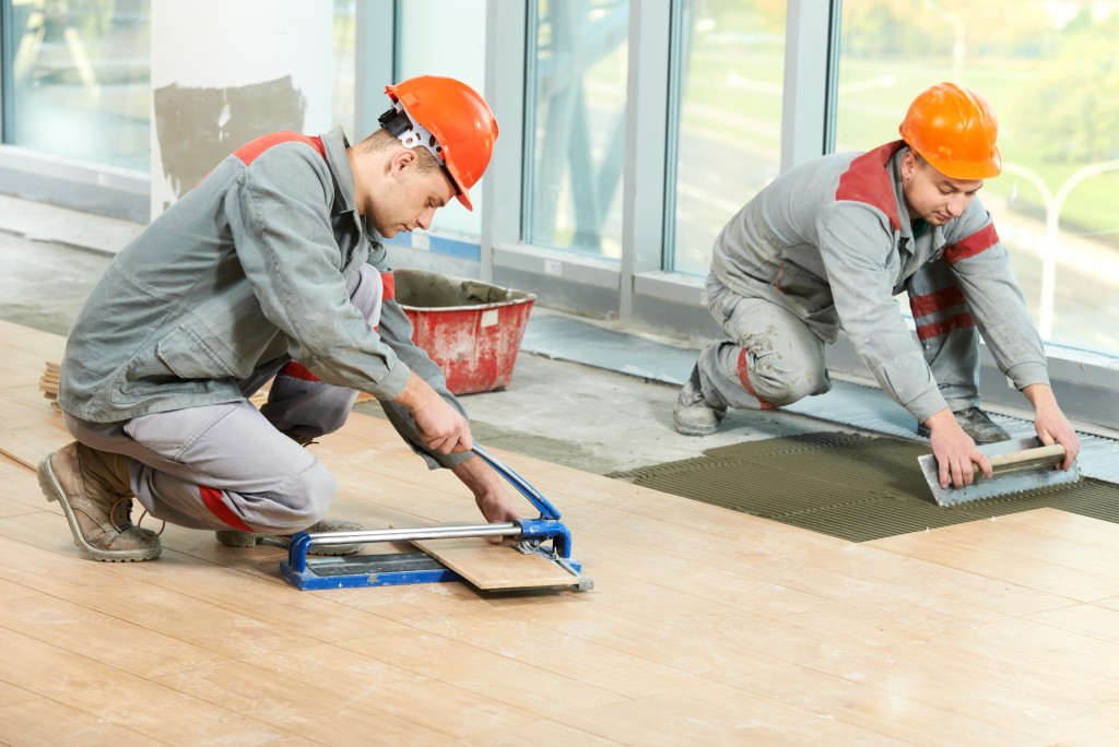 workers installing floor tiles