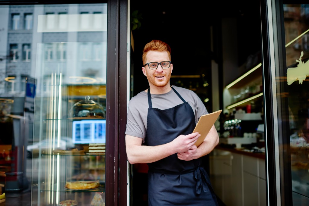 business owner standing in front of his store