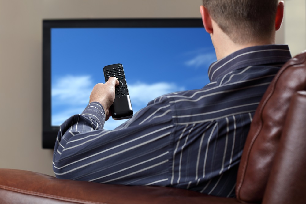 man sitting down focused on the tv