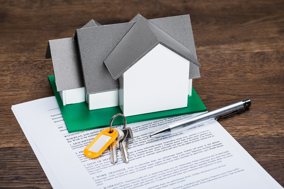 a miniature house and keys on top of a document