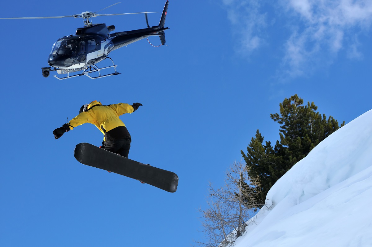 man jumping off a helicopter to snowboard