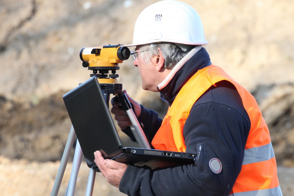 man holsing a laptop, land surveying