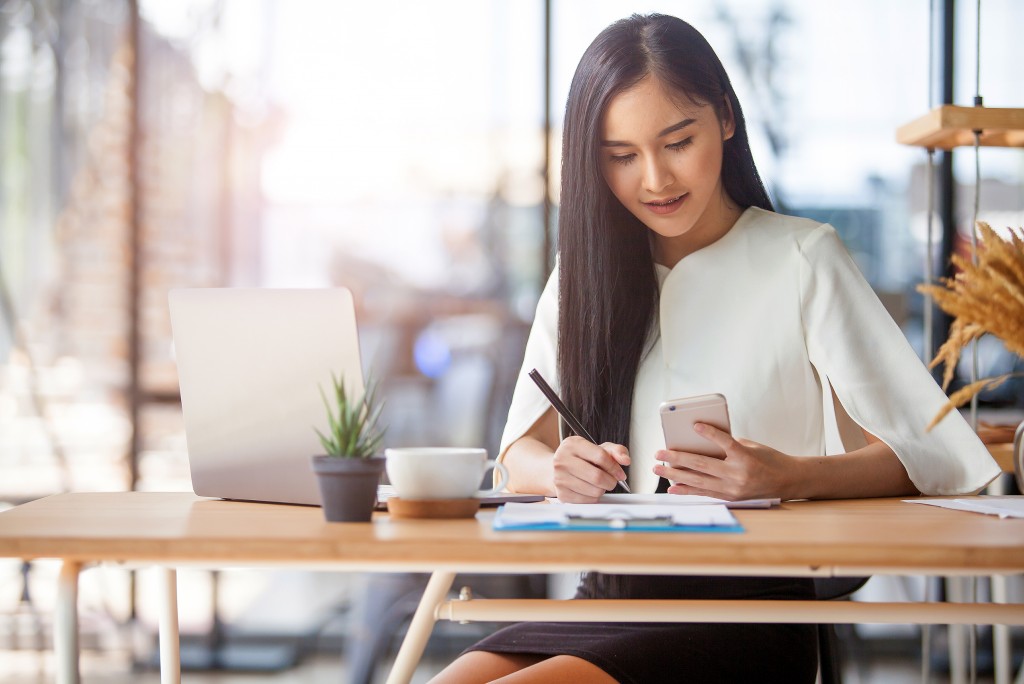 young woman working and swriting down her notes