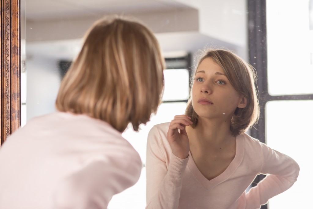 Young Woman Looking in Mirror