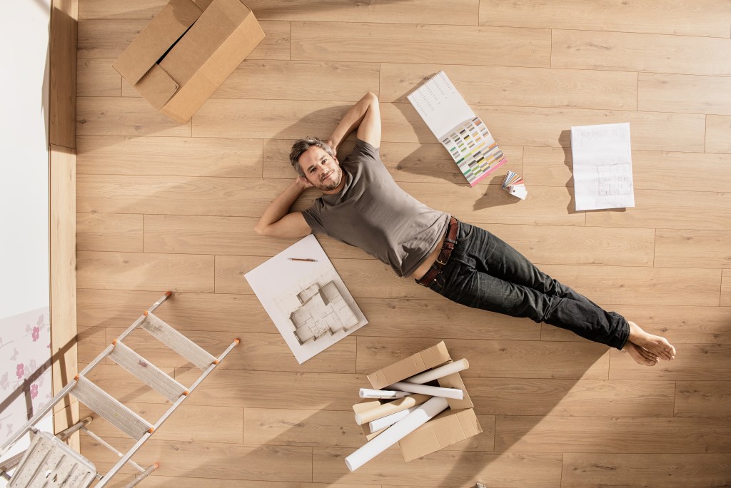 man laying on the floor of an empty room for renovation