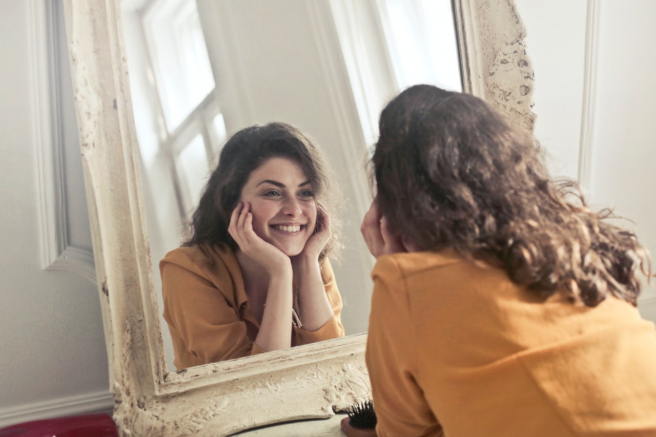 woman smiling facing the mirror