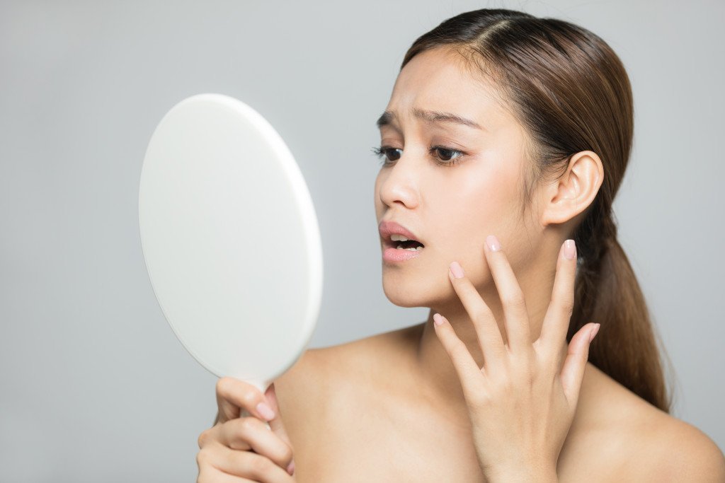 woman shocked looking at mirror