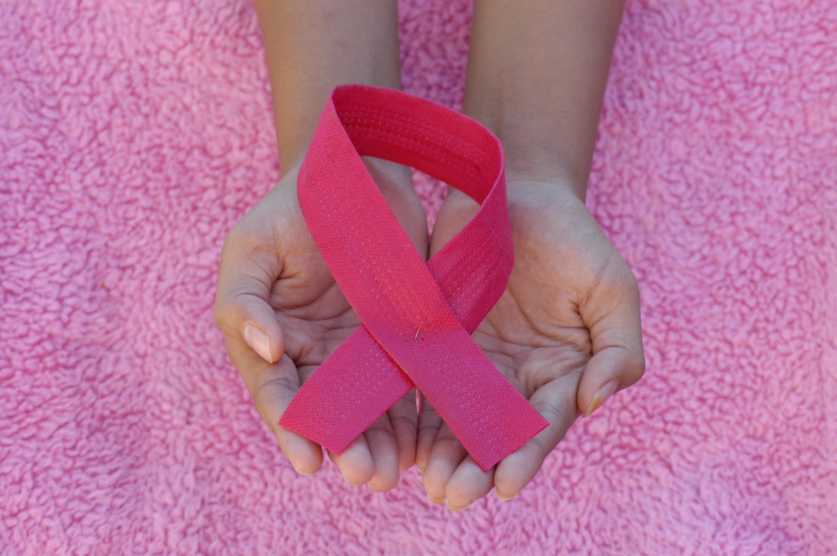 holding a pink ribbon