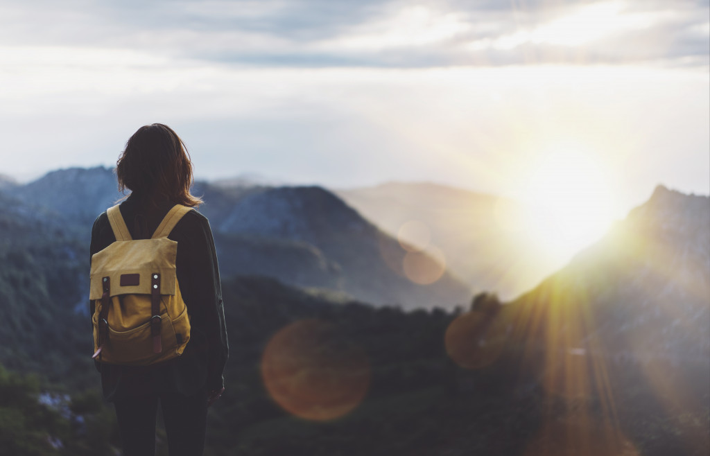 a woman enjoying her travel alone while watching the mountain view