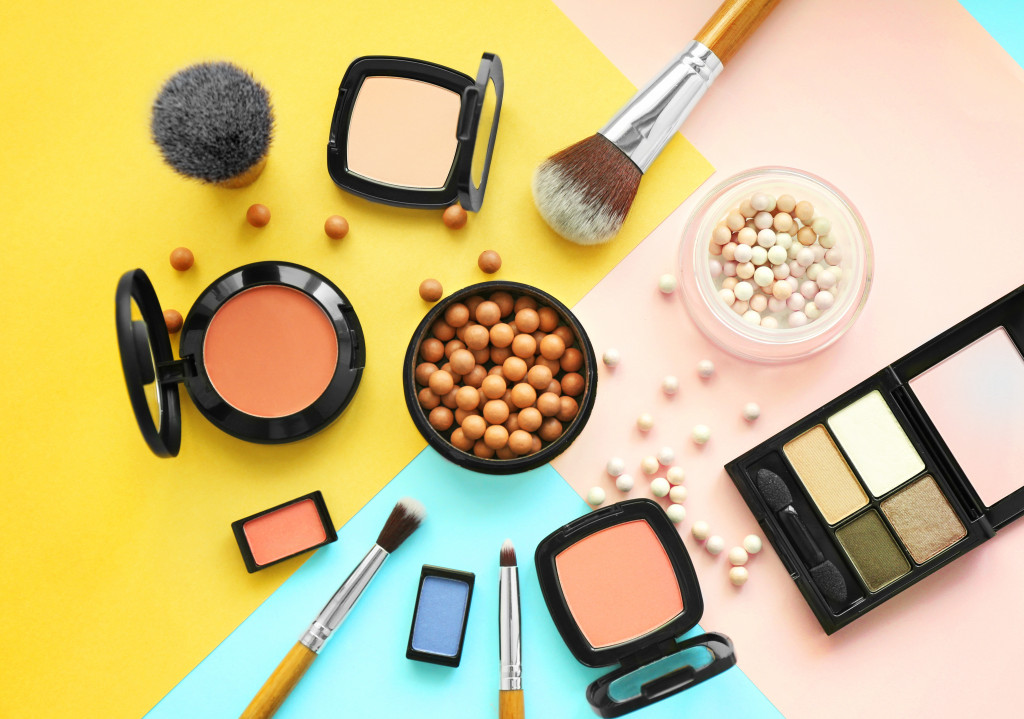 collection of face makeup in a brightly colored surface